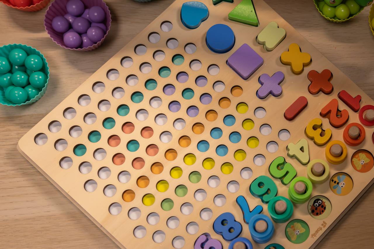 Spielbrett mit bunten Holzringen zum Stapeln und Sortieren