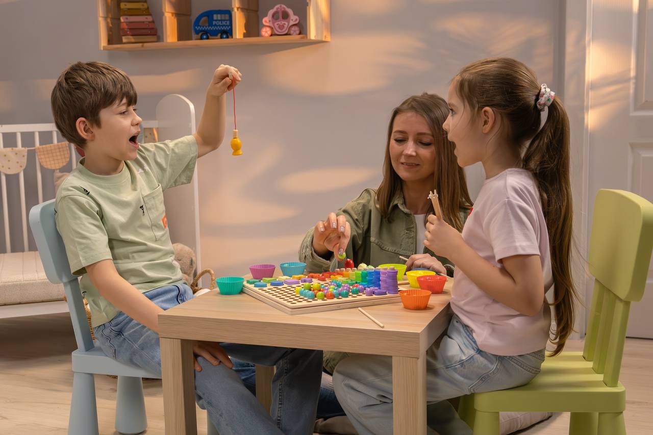 Familie spielt gemeinsam mit dem 5-in-1 Montessori Angelspiel