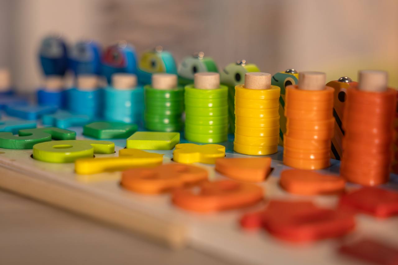 Bunte Holz-Stapelringe in Regenbogenfarben für das Montessori Angelspiel