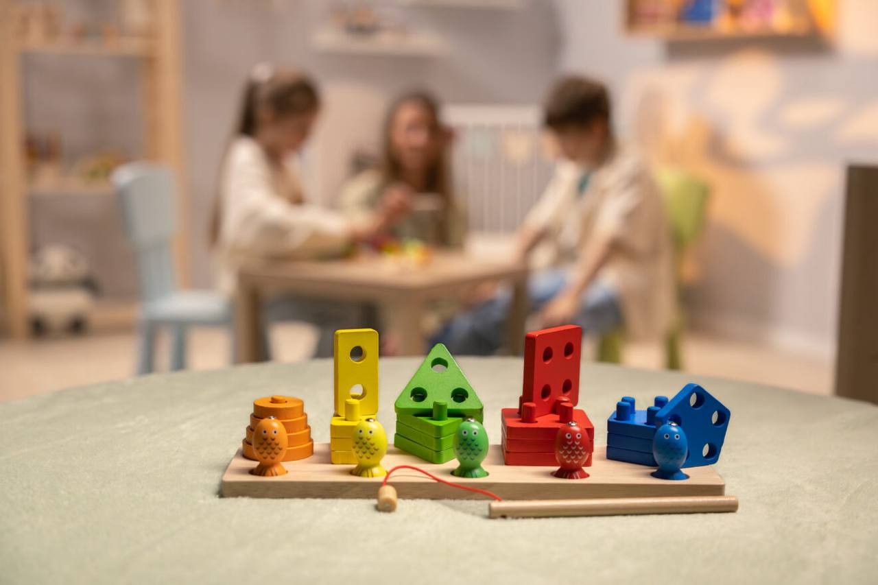 Kinderhände spielen mit den bunten Fischen und der Magnetangel